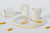 set de café de tazas, platos y jarra, en porcelana color blanco puro con esmalte interior y filo dorado